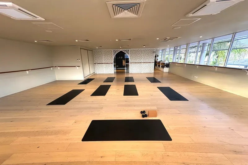 Inside the Flolo Mermaid Beach studio, bright beachside practice room with mats laid out and barre along the walls